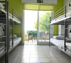 Кровать в общем номере с балконом и с красивым видом из окна в Lemongrass Hostel