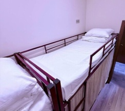 Кровать в мужском шестиместном номере в Берег